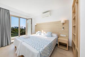 sypialnia z dużym łóżkiem i dużym oknem w obiekcie Apartamento Aquamarina 6 w mieście Cala Ferrera +17 zdjęć