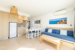 salon i kuchnia z kanapą i stołem w obiekcie Apartamento Aquamarina 6 w mieście Cala Ferrera