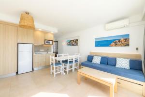 a living room and kitchen with a couch and a table at Apartamento Aquamarina 8 in Cala Ferrera