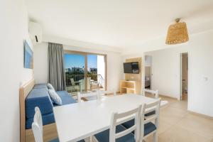 uma sala de estar com uma mesa branca e um sofá azul em Apartamento Aquamarina 8 em Cala Ferrera