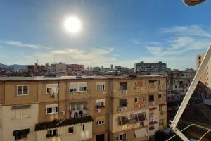 a view of a city with a building at Cozy sunlit apartment with scenic balcony view in Tirana