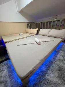 uma grande cama branca com luzes azuis no chão em Loft Baler with Kitchen & Ideal for Work from Home Setup em Baler