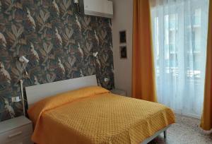 a bedroom with a bed with an orange comforter at Villa La Lanterna in Pietra Ligure