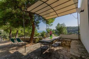 a patio with a table and chairs under an umbrella at Agriturismo Madonna Incoronata in Mattinata