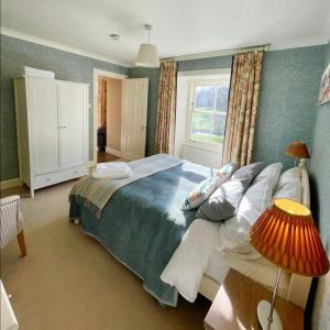 a bedroom with a bed with pillows and a window at River View Knockraich Farm in Fintry
