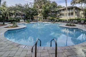 a large pool with chairs and a building in the background at 8121 Wendover Dunes in Hilton Head Island