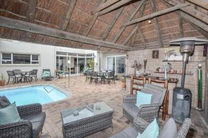 Cape Town的住宿－大西洋微風酒店，庭院设有游泳池、椅子和桌子。
