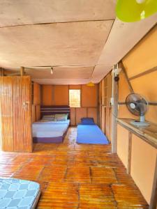 a room with two beds and a wooden floor at OYO Home 90737 Disan Baang Kiulu in Ranau