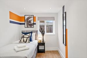 - une chambre avec un lit et une fenêtre dans l'établissement Fabulous Wimbledon 3 Bed Apartment with Outside Space, à Londres