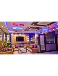 een woonkamer met banken en een flatscreen-tv bij Hotel President, Jodhpur in Jodhpur