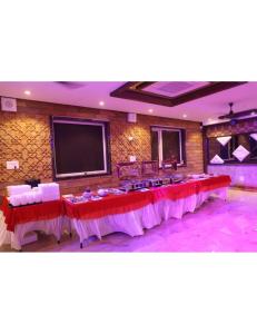 a banquet hall with tables and a flat screen tv at Hotel President, Jodhpur in Jodhpur