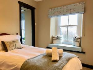 1 dormitorio con cama con espejo y ventana en Kirkstile Inn, en Loweswater