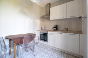 Una cocina con gabinetes blancos y una mesa de madera. en Maison de Ville avec Jardin "La Coquette", en Jonzac 9 fotos más