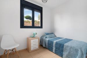1 dormitorio con 1 cama, 1 silla y 1 ventana en El Refugio en Sardina
