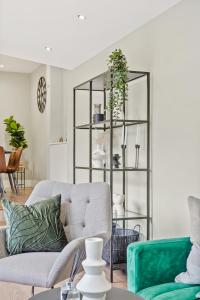 a living room with a gray couch and a glass shelf at Charming Wimbledon 3-Bed Apt with Outdoor Area in Wimbledon