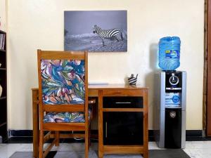a desk with a chair and a zebra picture on the wall at Splendid stay in Nakuru in Nakuru