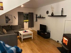 a living room with a couch and a table and a tv at Rooftop view apartment in Vardø