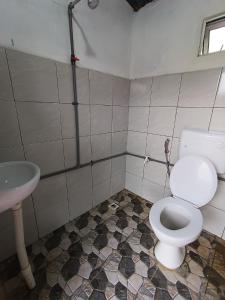 a bathroom with a toilet and a sink at OYO Home 90737 Disan Baang Kiulu in Ranau