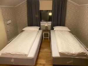 two twin beds in a room with a mirror at Rooftop view apartment in Vardø