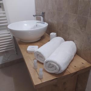 a bathroom with a sink and towels on a table at Casetta dei nonni in Pescantina