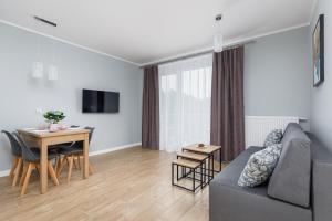 a living room with a couch and a table at Apartment Rybacka with Parking&Balcony by Renters in Międzywodzie