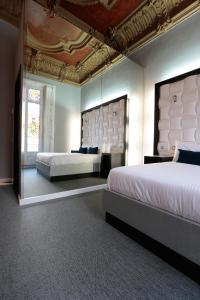 バルセロナにあるアムラ バルセロナ グラン ビアの天井の広いベッドルーム1室(ベッド2台付)が備わります。