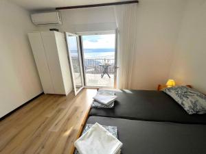 a bedroom with a bed and a view of the ocean at Apartment in Dramalj 42941 in Dramalj