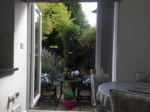 a patio with a table and chairs and a window at Oakleigh 1 bed ground floor garden view apartment FREE ONSITE PARKING in Stratford-upon-Avon