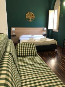 2 Betten in einem Schlafzimmer mit grünen Wänden in der Unterkunft Il Piccolo Albergo Matera in Matera