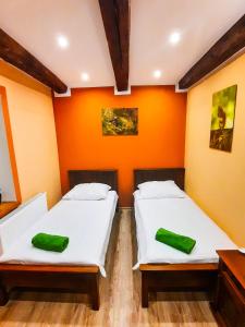 deux lits dans une chambre avec un mur orange dans l'établissement Gościna U kowala, à Lachowice 76 autres photos