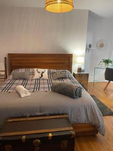 a bedroom with a bed with a suitcase on it at Le Namasté Auberge touristique in Lachute