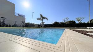 una piscina de agua azul frente a un edificio en Villa with private heated pool - Roda Golf & Beach Resort, en San Javier