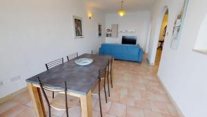 uma sala de jantar com mesa e cadeiras e um sofá azul em 6th floor seafront apartment with open sea views em Sliema