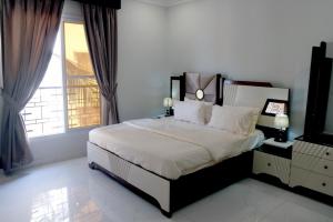 a bedroom with a large bed and a window at Al Rasheed Apartments second floor apartment in Karachi