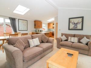 a living room with two couches and a table at Highfield Lodge in Windermere