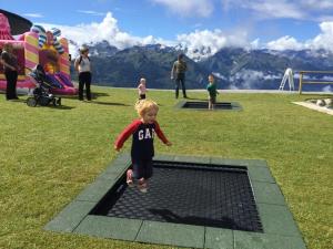 Un bambino che corre attraverso una grata in un parco di Ski-in & Out Alpine Style Apartment near Kitzbühel a Mittersill