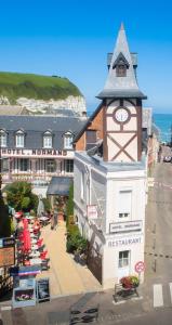 un edificio con una torre de reloj junto al océano en Hôtel Normand Yport Hôtel Ambiance familiale non étoilé, en Yport