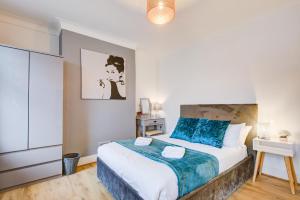 a bedroom with a large bed with blue pillows at Statera Apartments - 2-Bed House in Stratford in London