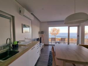 a kitchen with a table and a view of the ocean at Bay House - Seascape Apartment in Ponta Delgada