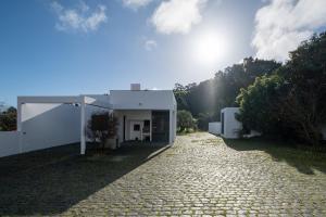 une maison sur le côté d'une route dans l'établissement Azores Green Woods Villa, à São Vicente Ferreira