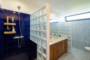 baño con lavabo y ducha con azulejos azules en Azores Green Woods Villa, en São Vicente Ferreira