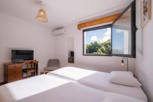 ein Schlafzimmer mit zwei weißen Betten und einem Fenster in der Unterkunft Azores Green Woods Villa in São Vicente Ferreira