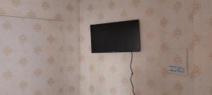 uma televisão de ecrã plano pendurada numa parede em Homestay 2 em Daca