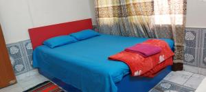 um quarto com uma cama azul e uma cabeceira vermelha em Homestay 2 em Daca