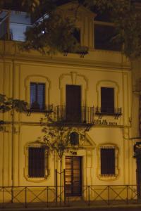 um edifício amarelo com uma árvore em frente em Casa Xanadu Seville - 6 bedroom Andalusian home with terraces em Sevilha