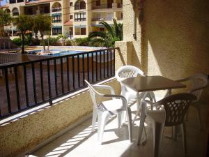 a table and chairs on a balcony with a building at Gladmar Apartment in La Mata