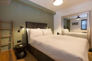 1 dormitorio con 1 cama grande y espejo en The Duke, en Trowbridge