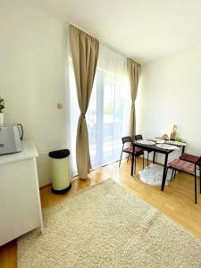 een woonkamer met een tafel en een groot raam bij Libás Apartman in Keszthely