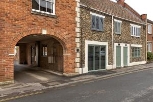 a brick building with an archway on a street at The Duke in Trowbridge