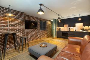 a living room with a couch and a brick wall at The Duke in Trowbridge